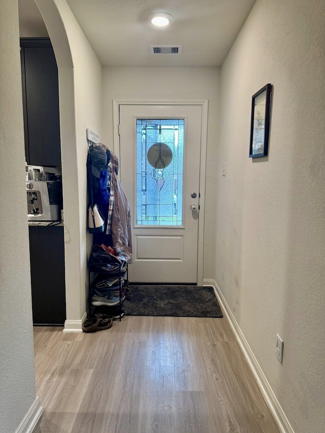 22043 Rocky Reserve Dr, Northwest Harris, TX 77447 - doorway to outside with visible vents, baseboards, wood finished floors, arched walkways, and a textured wall