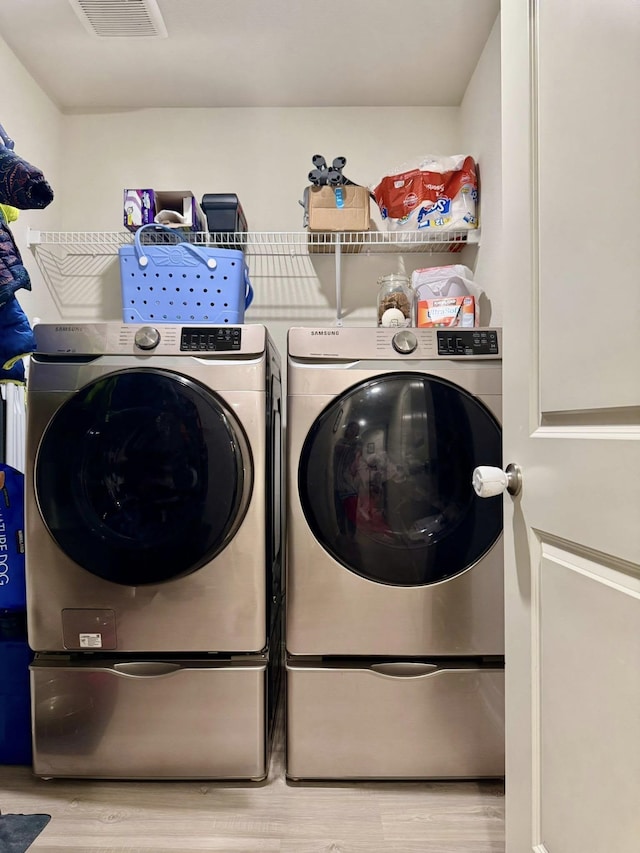 22043 Rocky Reserve Dr, Northwest Harris, TX 77447 - laundry room with visible vents, washing machine and dryer, laundry area, and wood finished floors