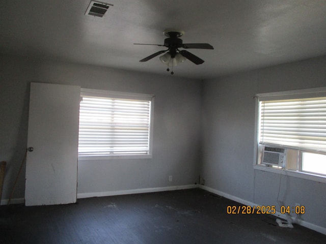 spare room with a ceiling fan, wood finished floors, baseboards, and visible vents