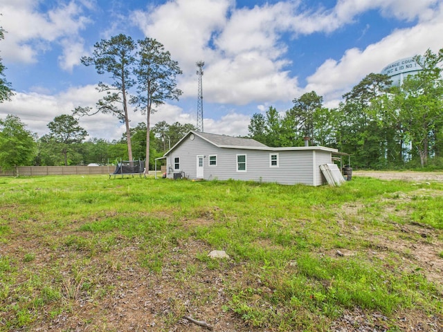 1325 S Main St, Vidor, TX 77662 - back of house featuring a trampoline and fence
