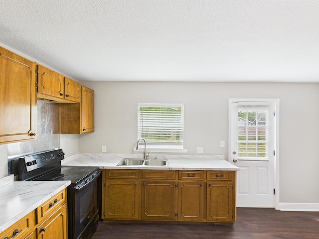 1325 S Main St, Vidor, TX 77662 - kitchen with brown cabinets, dark wood finished floors, electric range, and a sink