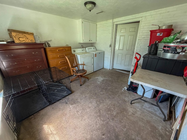 220 Dupuis St, Bridge City, TX 77611 - laundry area with separate washer and dryer, cabinet space, a textured ceiling, and brick wall
