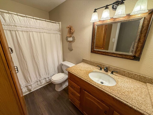 220 Dupuis St, Bridge City, TX 77611 - bathroom with wood finished floors, vanity, a textured wall, toilet, and shower / bathtub combination with curtain