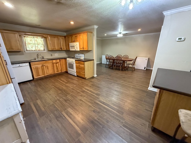 220 Dupuis St, Bridge City, TX 77611 - kitchen with white appliances, crown molding, dark countertops, a sink, and dark wood-style floors