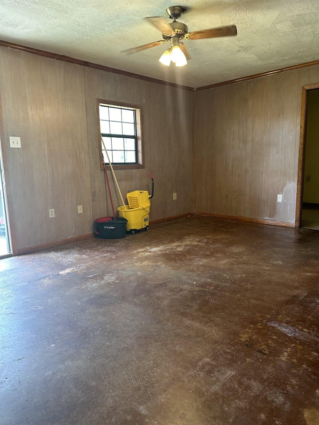 unfurnished room with ceiling fan and wood walls