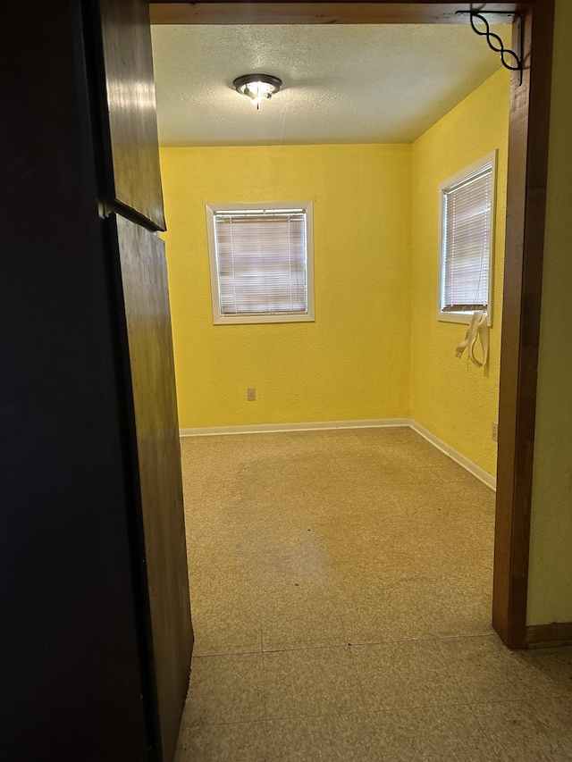 unfurnished room featuring a textured ceiling