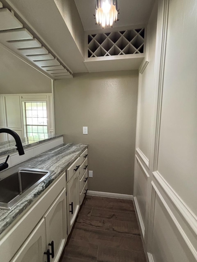 1401 Buckingham Dr, Orange, TX 77632 - kitchen with a sink, dark wood-style flooring, white cabinetry, and baseboards