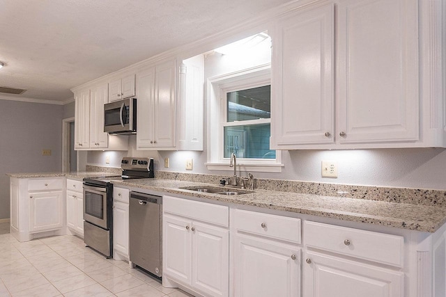 334 Pinehurst Dr, Sour Lake, TX 77659 - kitchen featuring stainless steel appliances, a sink, white cabinetry, light stone countertops, and ornamental molding