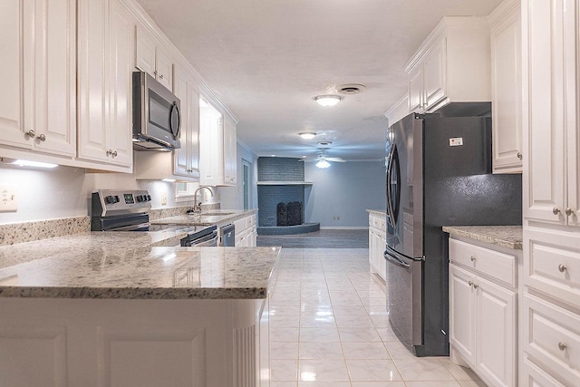 334 Pinehurst Dr, Sour Lake, TX 77659 - kitchen featuring appliances with stainless steel finishes, ceiling fan, a sink, white cabinets, and light marble finish floors
