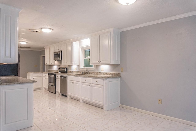 334 Pinehurst Dr, Sour Lake, TX 77659 - kitchen featuring stainless steel appliances, a sink, crown molding, light marble finish flooring, and white cabinetry