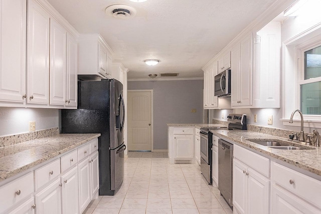 334 Pinehurst Dr, Sour Lake, TX 77659 - kitchen with a sink, appliances with stainless steel finishes, white cabinets, light stone countertops, and ornamental molding