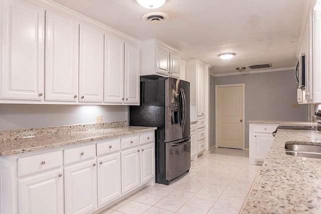 334 Pinehurst Dr, Sour Lake, TX 77659 - kitchen featuring appliances with stainless steel finishes, white cabinets, crown molding, light stone countertops, and light marble finish flooring