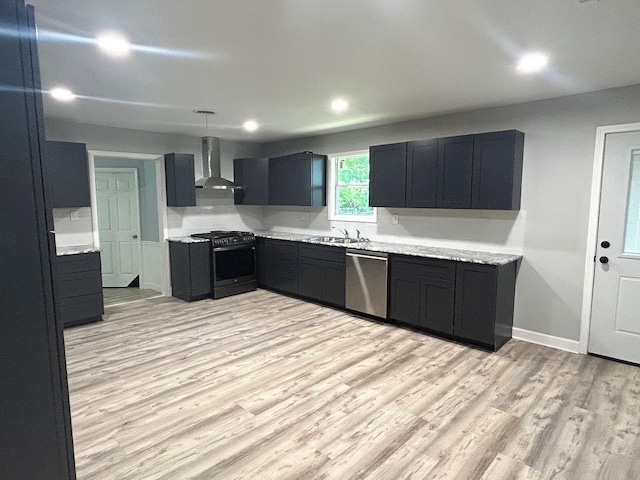 850 Orange St, Vidor, TX 77662 - kitchen featuring gas range, stainless steel dishwasher, wall chimney range hood, light wood-type flooring, and light countertops