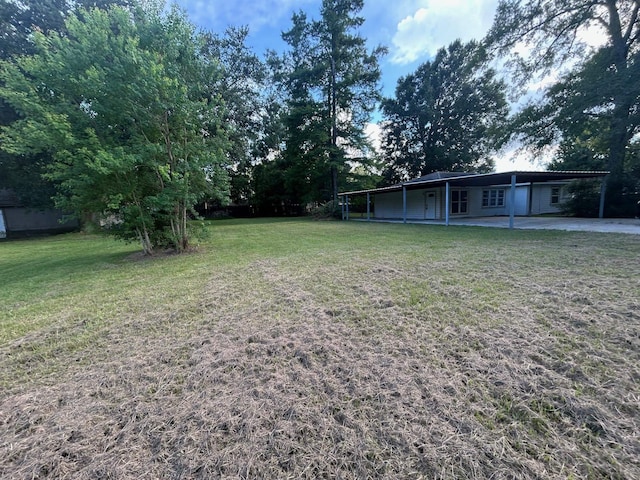 850 Orange St, Vidor, TX 77662 - view of grassy yard with an attached carport