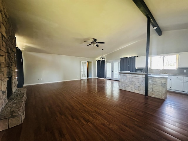 unfurnished living room with dark wood-type flooring, ceiling fan, lofted ceiling with beams, and a sink