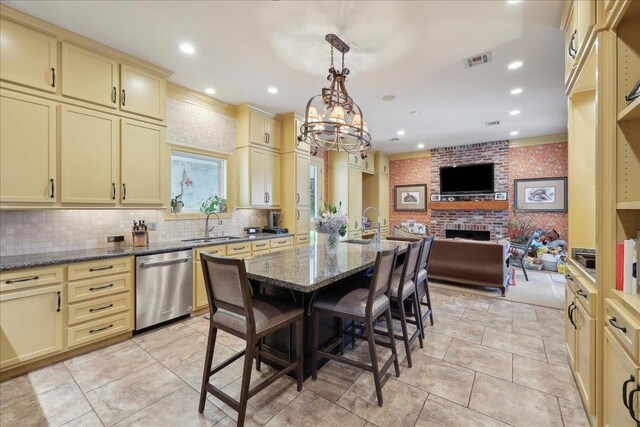 5160 Littlechase Dr, Beaumont, TX 77706 - kitchen with cream cabinetry, dishwasher, open floor plan, a brick fireplace, and recessed lighting