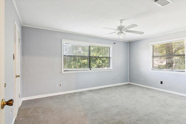 unfurnished room featuring carpet, a wealth of natural light, and crown molding