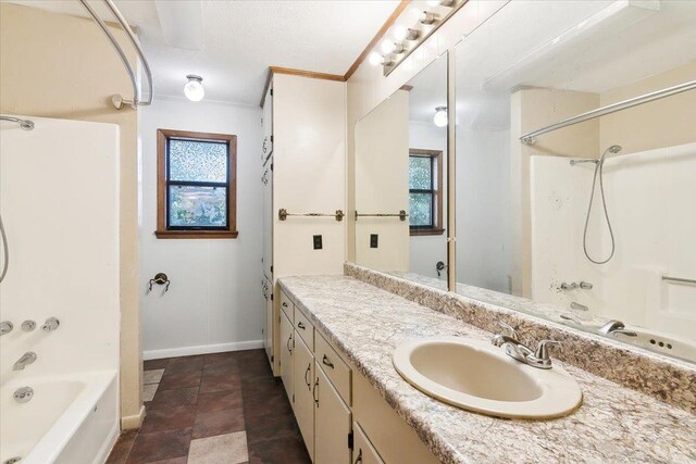 bathroom with vanity, a healthy amount of sunlight, crown molding, and shower / washtub combination