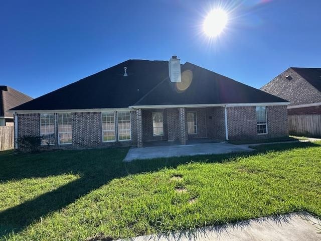 rear view of house with a yard and a patio