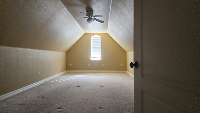 bonus room with vaulted ceiling, light colored carpet, ceiling fan, and a textured ceiling