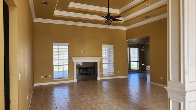 unfurnished living room featuring light tile patterned floors, a tray ceiling, ornamental molding, and ceiling fan