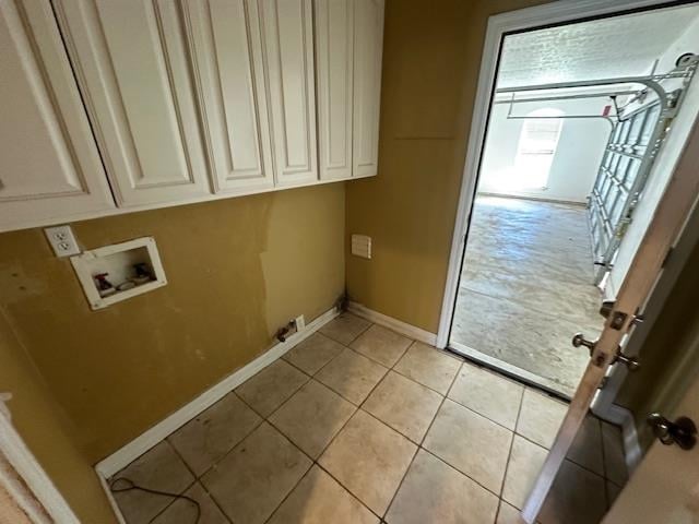 clothes washing area featuring washer hookup, cabinets, and light tile patterned flooring