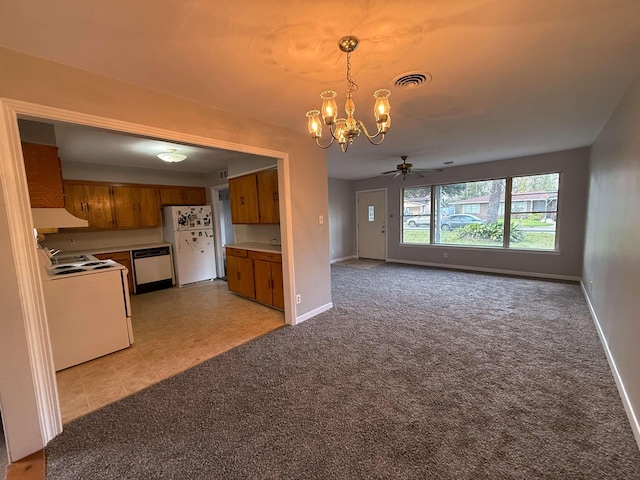 kitchen featuring ceiling fan with notable chandelier, light colored carpet, white appliances, and hanging light fixtures