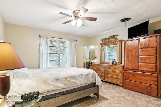 bedroom with ceiling fan and a textured ceiling