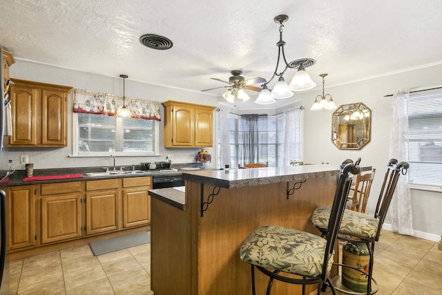 kitchen featuring a kitchen bar, decorative light fixtures, ceiling fan, and sink