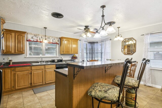 kitchen featuring a kitchen bar, decorative light fixtures, ceiling fan, and sink