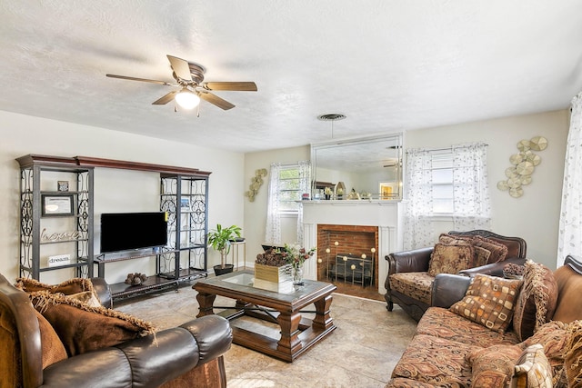 living room with ceiling fan and a textured ceiling