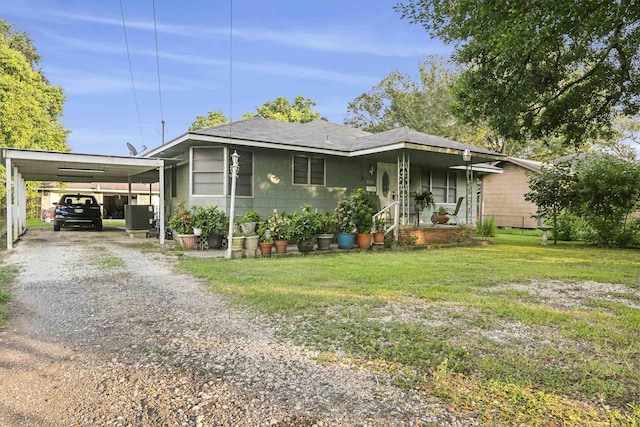 view of front of house featuring a carport, a front yard, and central AC