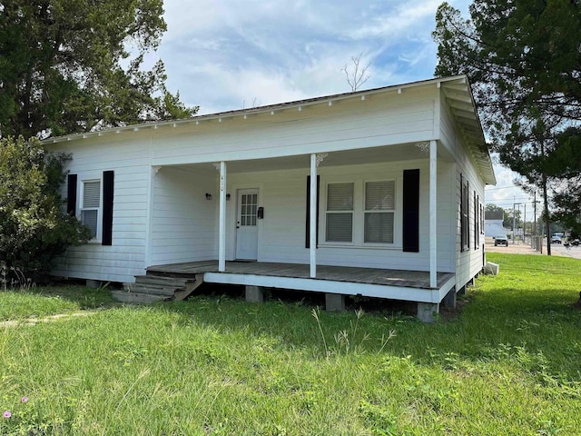 view of front of house featuring covered porch and a front yard