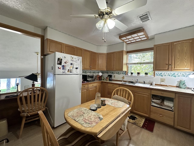 466 Galahad Loop Rd, Woodville, TX 75979 - kitchen with light wood-style flooring, freestanding refrigerator, a ceiling fan, visible vents, and a sink