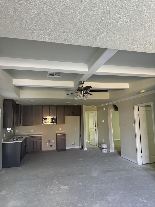 unfurnished living room with beamed ceiling, concrete floors, ceiling fan, and coffered ceiling