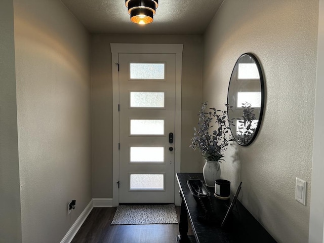 foyer entrance featuring a textured ceiling and dark hardwood / wood-style flooring