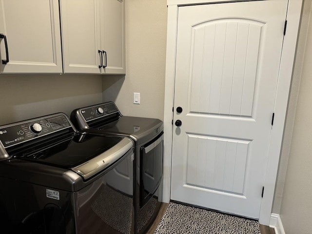 washroom with cabinets and washing machine and clothes dryer