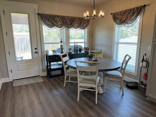 dining area with dark hardwood / wood-style flooring and a chandelier