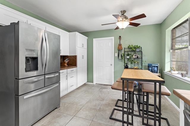 1135 Brandywine St, Beaumont, TX 77706 - kitchen with stainless steel fridge, a ceiling fan, white cabinetry, dark countertops, and light tile patterned floors