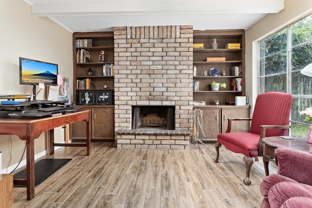 1135 Brandywine St, Beaumont, TX 77706 - living area featuring beam ceiling, wood finished floors, a fireplace, and built in shelves