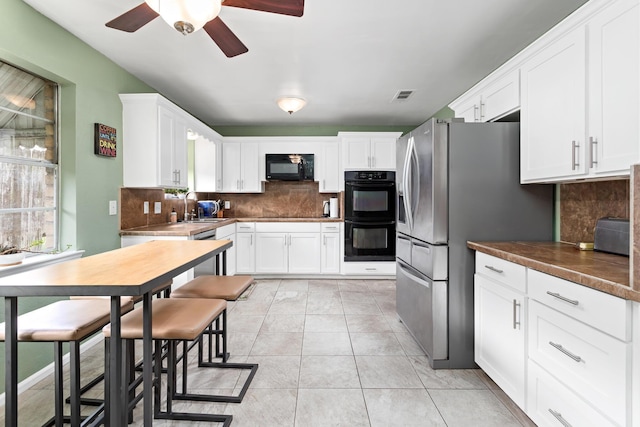 1135 Brandywine St, Beaumont, TX 77706 - kitchen featuring black appliances, a ceiling fan, and decorative backsplash