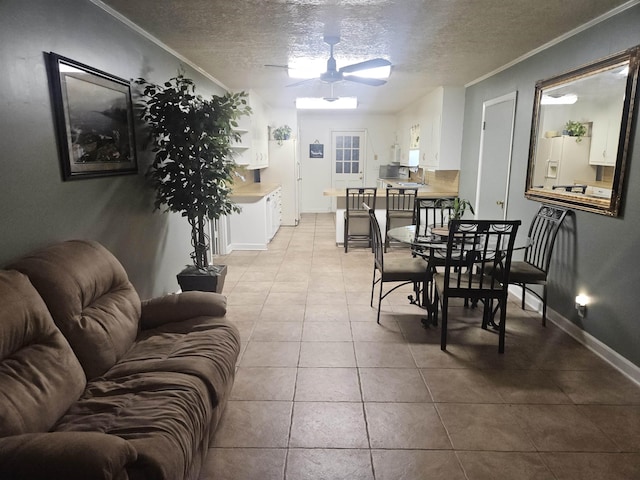 dining room featuring ceiling fan, light tile patterned flooring, a textured ceiling, and ornamental molding