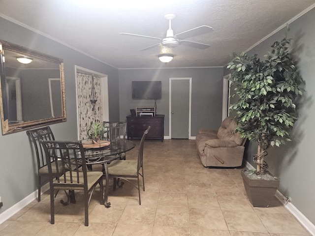 tiled dining space featuring a textured ceiling, ceiling fan, and ornamental molding