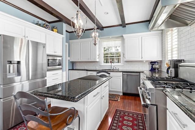 kitchen with a center island, beamed ceiling, white cabinets, exhaust hood, and appliances with stainless steel finishes