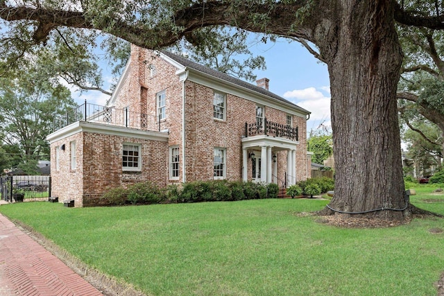 view of front of home featuring a balcony and a front lawn