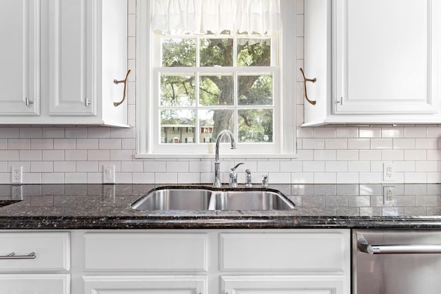 kitchen featuring white cabinetry, sink, dark stone counters, and tasteful backsplash