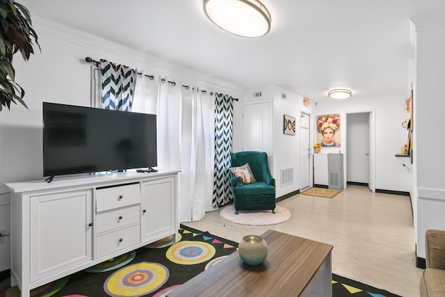 living room featuring crown molding and light wood-type flooring