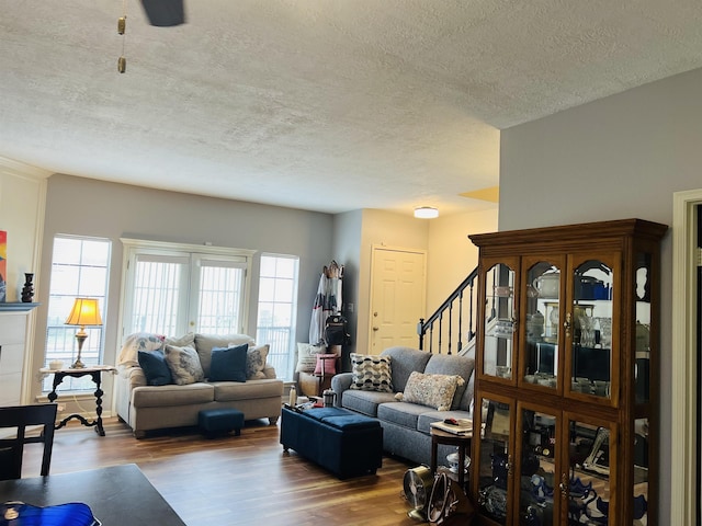 living room with wood-type flooring and a textured ceiling