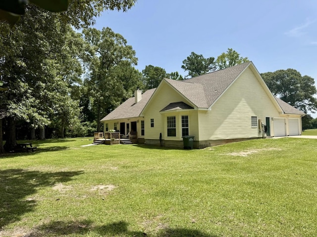 15590 S Fm 92, Spurger, TX 77660 - rear view of property with a lawn, an attached garage, a wooden deck, a chimney, and roof with shingles