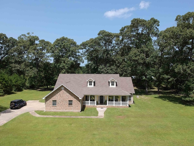 15590 S Fm 92, Spurger, TX 77660 - new england style home featuring a porch, a front lawn, and driveway